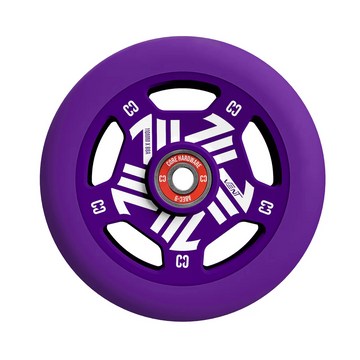 The CORE Vent 110mm Stunt Scooter Wheel by CORE features a purple hollow core, black and white geometric spokes, and a red center bearing. Lightweight and designed for stunt scooters, this wheel is isolated on a white background.