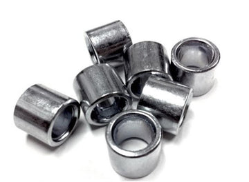 A scattered pile of seven Sushi Skateboard Bearing Spacers, made of shiny metal and cylindrical in shape, is displayed on a white background.