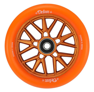 An image showcases the Blunt Envy Delux 120mm Stunt Scooter Wheel in vibrant orange, featuring a bronze metallic hub with intricate spoke designs crafted from anodized aluminum. The brand name "Delux" is elegantly printed in white on the wheel, making it an ideal choice for enthusiasts of stunt scooter wheels.