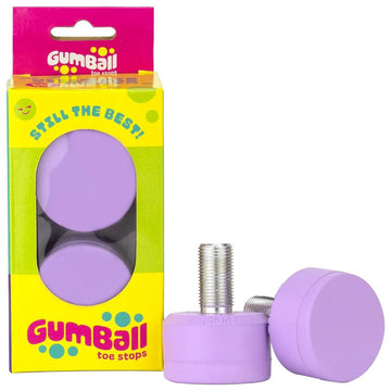 A pair of Gumball Roller Skate Long 30mm 83A Toe Stops in grape purple highlights their unmatched stopping power. One toe stop stands upright and the other lies down in a pink and yellow box with transparent windows, boasting, "Still the Best!" for optimal skating control.
