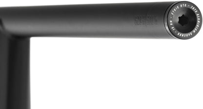 Close-up of the Ethic Flush Aluminium Stunt Scooter Bar Ends in black, showcasing a visible bolt head at the end of the black metal handlebar. The bar end is engraved to indicate it is crafted from 7050 aluminum, highlighting its durable and stylish design by Ethic. The background is white.