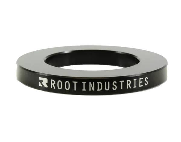The Root Industries 5mm Headset Spacer - Black is a circular spacer with "ROOT INDUSTRIES" in white on the side, featuring a wide central hole—perfect for SCS compression setups.