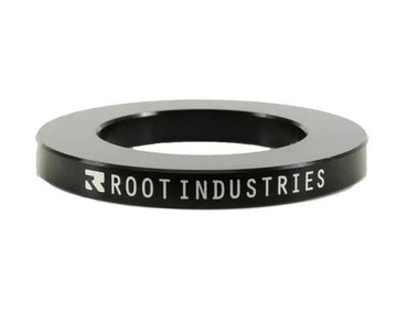 The Root Industries 5mm Headset Spacer - Black is a circular spacer with "ROOT INDUSTRIES" in white on the side, featuring a wide central hole—perfect for SCS compression setups.