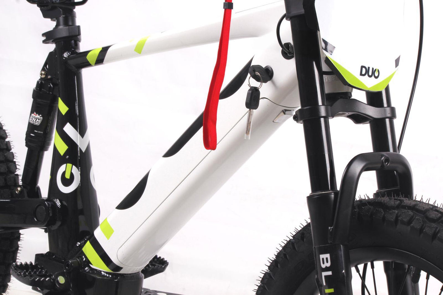 Close-up of the Duo 18" Blitz Kids Electric Balance Bike in white/black, highlighting the battery compartment with key and red strap, plus visible front suspension fork and part of the tires.