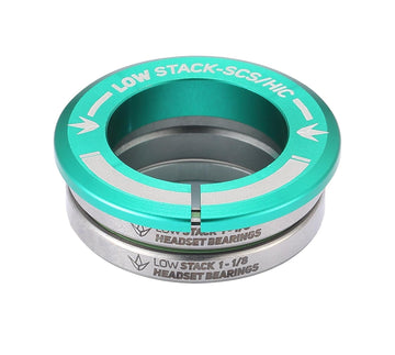 A teal, silver, and green circular metal component from Blunt Envy labeled "Low Stack SCS Integrated Stunt Scooter Headset" and featuring sealed bearings for durability, intended for use in a stunt scooter headset assembly with the SCS compression system.