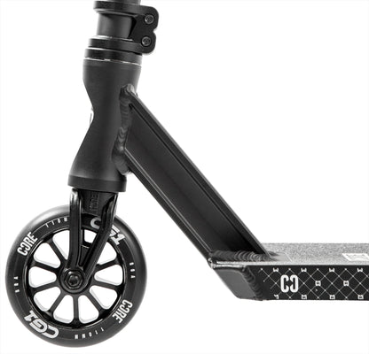 Close-up of the CORE CG1 Complete Stunt Scooter - Black by CORE, highlighting the textured diamond-patterned deck, sturdy fork, and wheel featuring "CORE" in white letters.