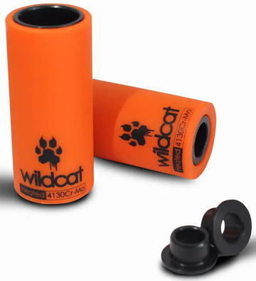 Two orange cylindrical Wildcat Pro Mini BMX Pegs by Wildcat, one upright and one lying down, alongside two small black circular attachments that resemble BMX pegs.