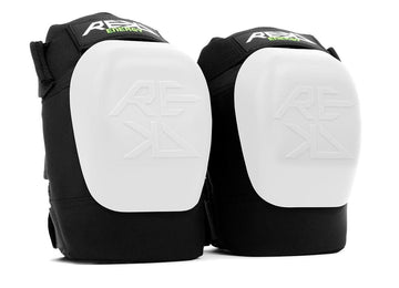 A pair of REKD Energy Patrol Ramp Knee Skate Protection Pads - White, showcasing the "REKD" logo on the front. These pads feature a robust white shell with black padding designed to absorb impact energy, providing optimal knee protection for extreme sports or physical activities.