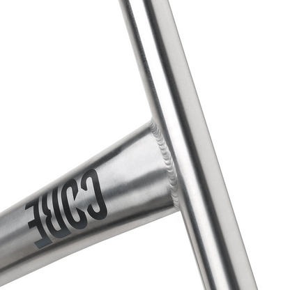 Close-up of a welded joint on a brushed metal frame, with "CORE" printed in black—showcasing the premium craftsmanship of CORE Nova V2 Titanium Oversized HIC Stunt Scooter Bars (Raw, 630mm x 610mm).