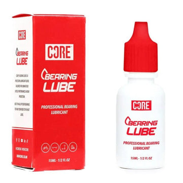 The red and white packaging for the CORE Bearing Lube 15ml Bottle emphasizes its function in bearing maintenance. On the left, a rectangular box provides information about the professional skate lubricant, while on the right, the small bottle with a red dropper cap underscores "Professional Bearing Lubricant" to ensure optimal performance.