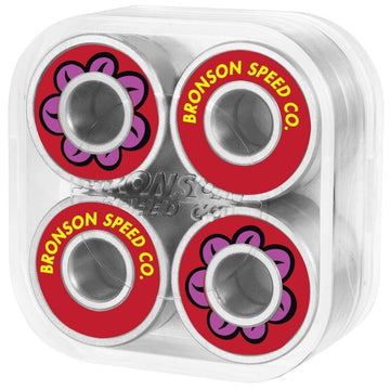 The Bronson Speed Co. Fabiana Delfino Pro G3 Skateboard Bearings pack includes eight bearings presented in a transparent case. Each bearing features a red ring with "Bronson Speed Co." in white and a vibrant pink and purple flower design, ideal for skateboard enthusiasts.
