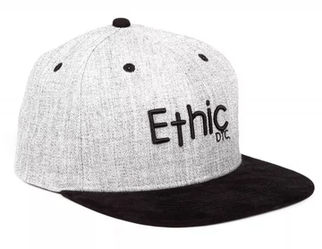 The Ethic DTC Snapback Cap - Deerstalker Grey showcases a timeless snapback style, featuring a gray crown paired with a black brim. The front prominently displays the word "Ethic" embroidered in black, while the smaller letters "DTC" are artistically positioned below, emphasizing its distinctive embroidered Ethic logo.