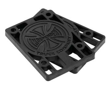 A pair of black 1/4" Independent Skateboard Riser Pads, embossed with the "Independent" logo at the center, showcases a circular design and corner holes for durability. Perfect for Indy Trucks enthusiasts who value both reliability and style.