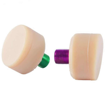Displayed on a white background are two cylindrical Gumball V2 Natural Toe Stoppers, each with a threaded base—one green and one purple. Both beige stoppers from Gumball ensure excellent skating control and stopping power.