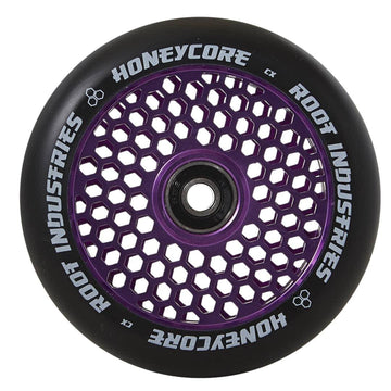 The Root Industries Honeycore 120mm Stunt Scooter Wheel in black and purple is displayed, showcasing an eye-catching honeycomb design. The inner core highlights the distinctive pattern, with "Honeycore Wheels" and "Root Industries" tastefully printed in white around the outer edge.
