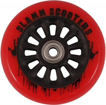 A close-up of the Slamm Nylon Core 110mm Scooter Wheel - Red showcases its appealing design. The wheel, perfect for stunt scooter riders, features a striking red outer section with a black core adorned with multiple spokes. A unique black paint splatter pattern enhances the text on the wheel, while ABEC 9 Chrome Bearings ensure smooth performance.