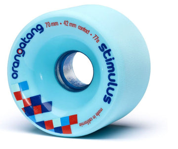 This light blue Orangatang Stimulus longboard wheel, adorned with red and blue checker-patterned graphics, is ideal for smooth slides. The text on the wheel reads "Orangatang Stimulus Wheels" and it features specifications such as being 70 mm in diameter with a 42 mm contact patch and a durometer of 77a, all made in California.