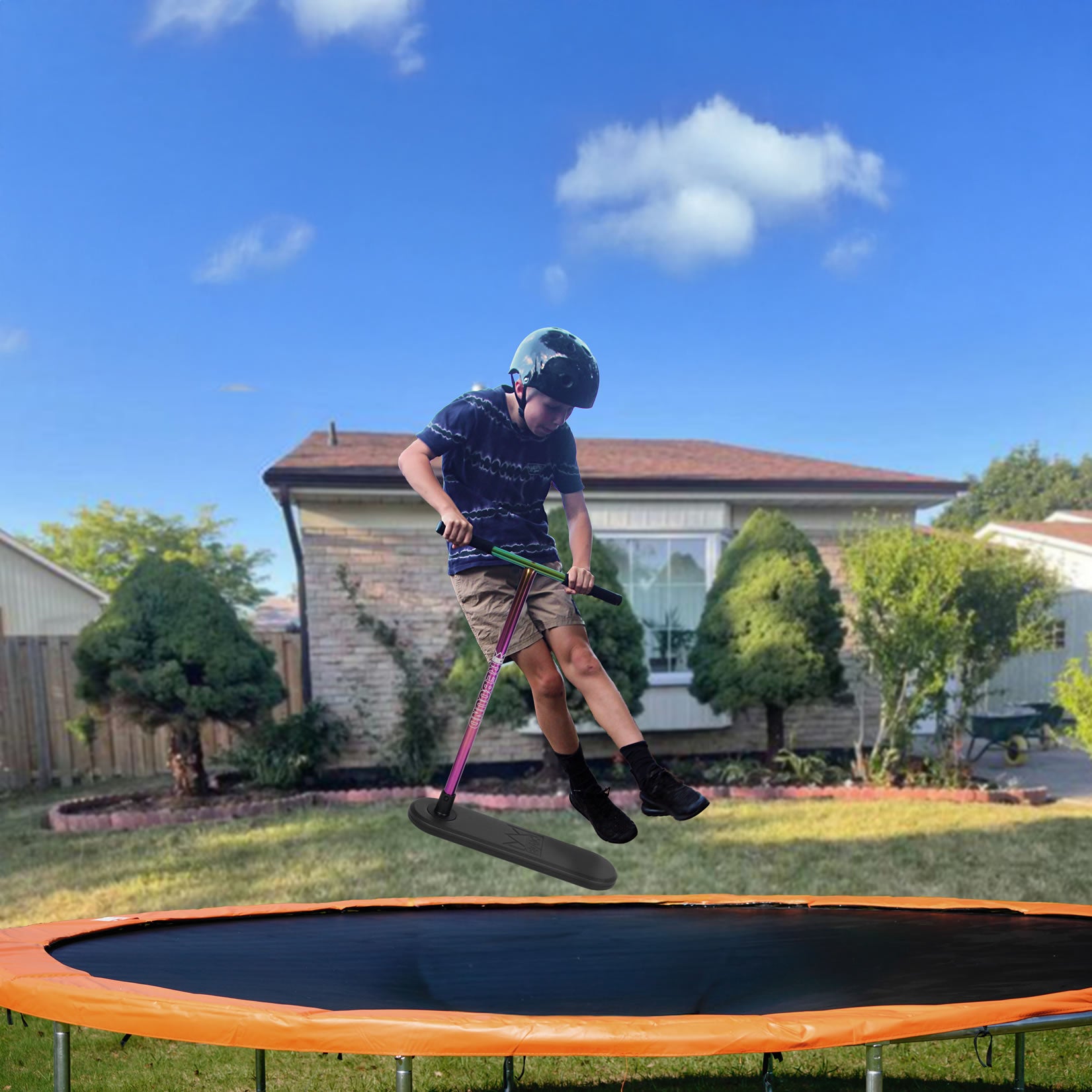 A boy wearing a helmet jumps on a backyard trampoline, holding the Legacy Rebound Indoor Trampoline Scooter - Neochrome by Legacy, with a house, trees, and blue sky in the background.